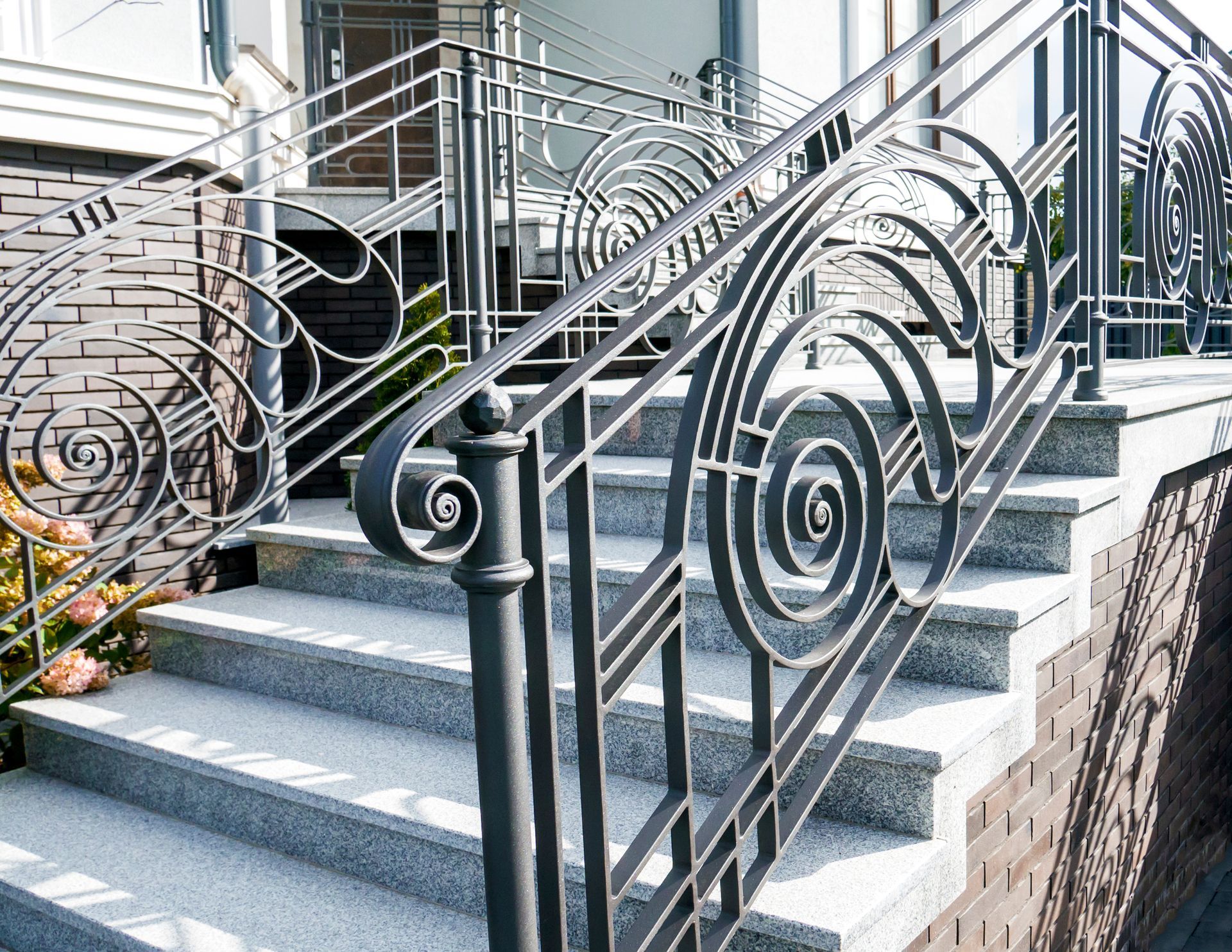 A close up of a wrought iron railing on a set of stairs.