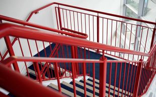 A red railing on a set of stairs in a building