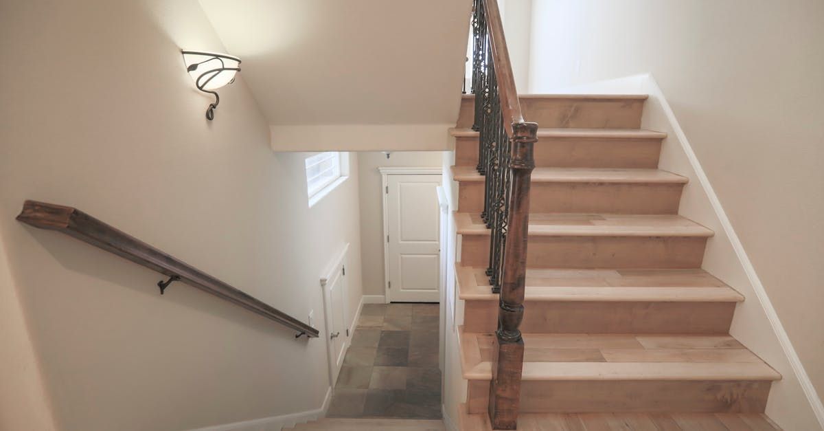 A wooden staircase with a metal railing leading up to the second floor of a house.