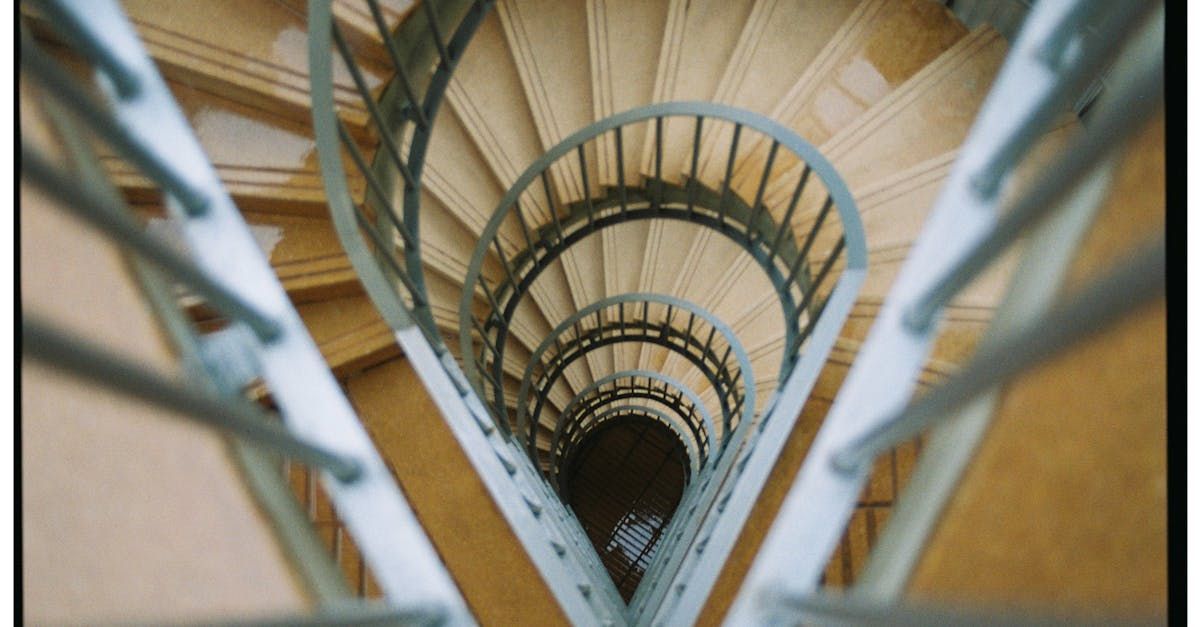 Looking down a spiral staircase with a metal railing.