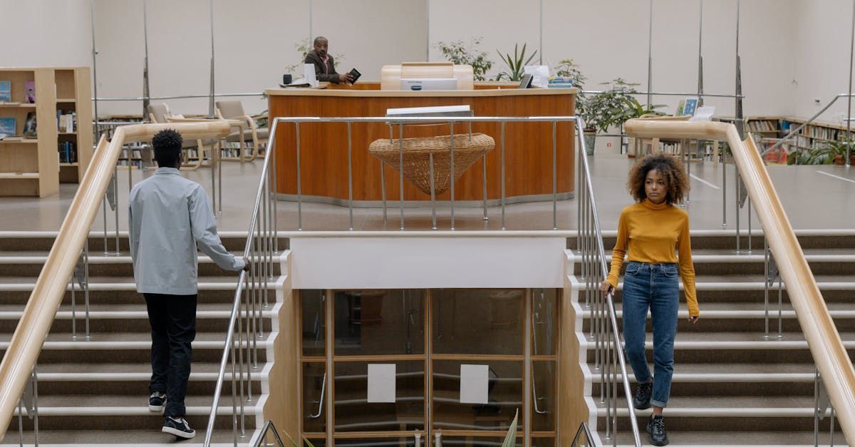 A man and a woman are walking down stairs in a building.
