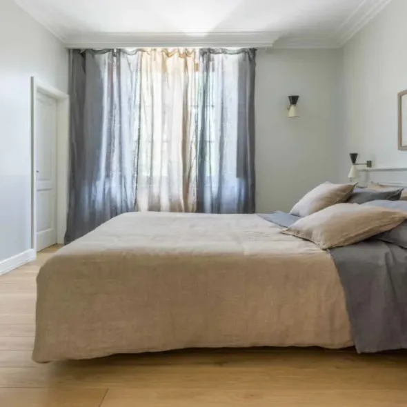 Una camera da letto con un letto, tende e una finestra.