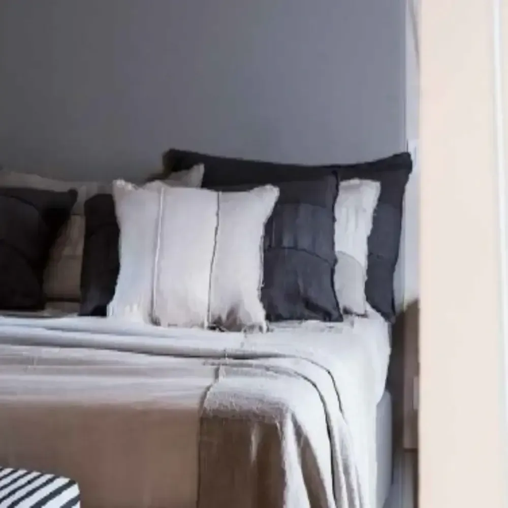 Un letto con una coperta e dei cuscini sopra