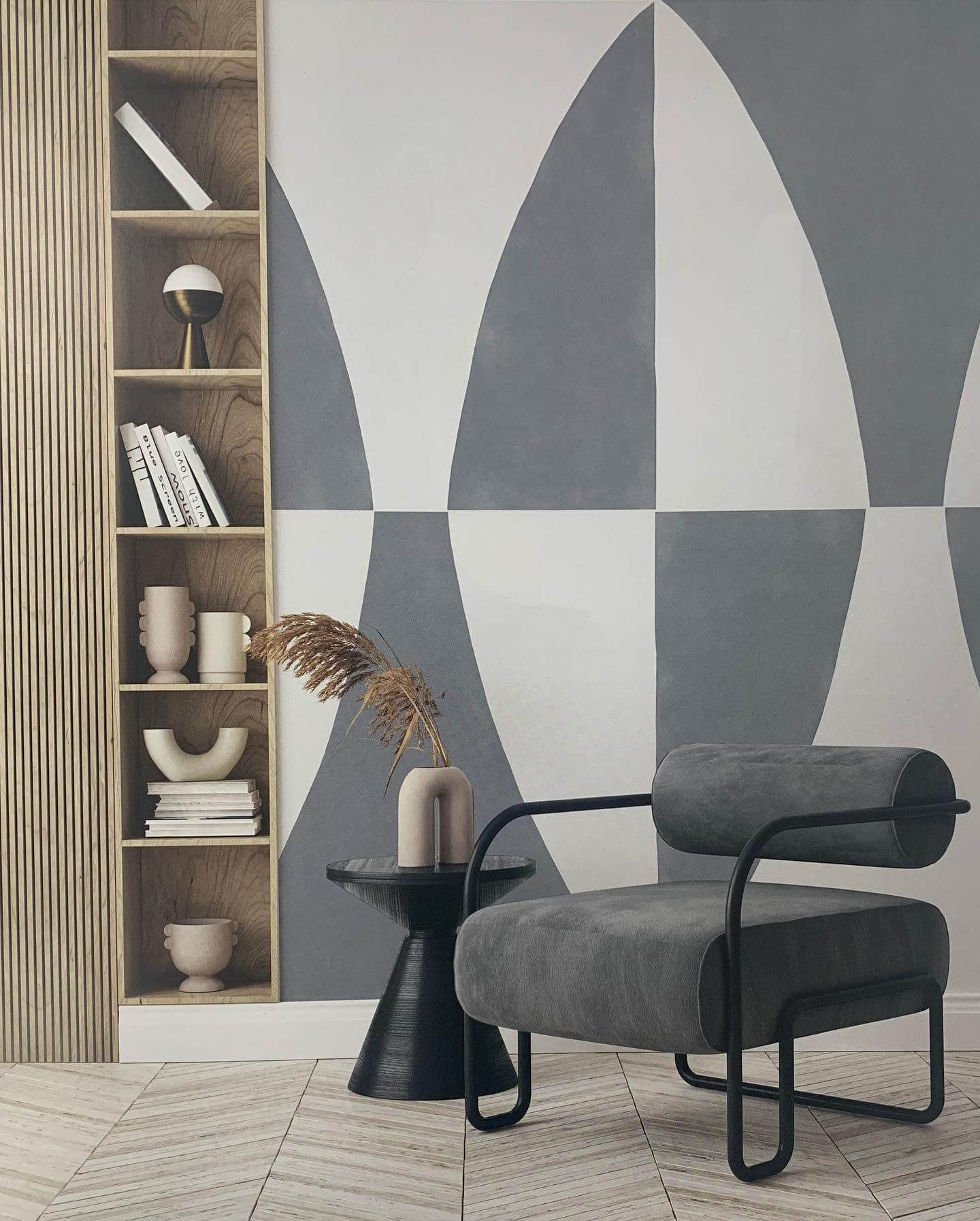 Una sedia è appoggiata davanti a una parete con un motivo geometrico.