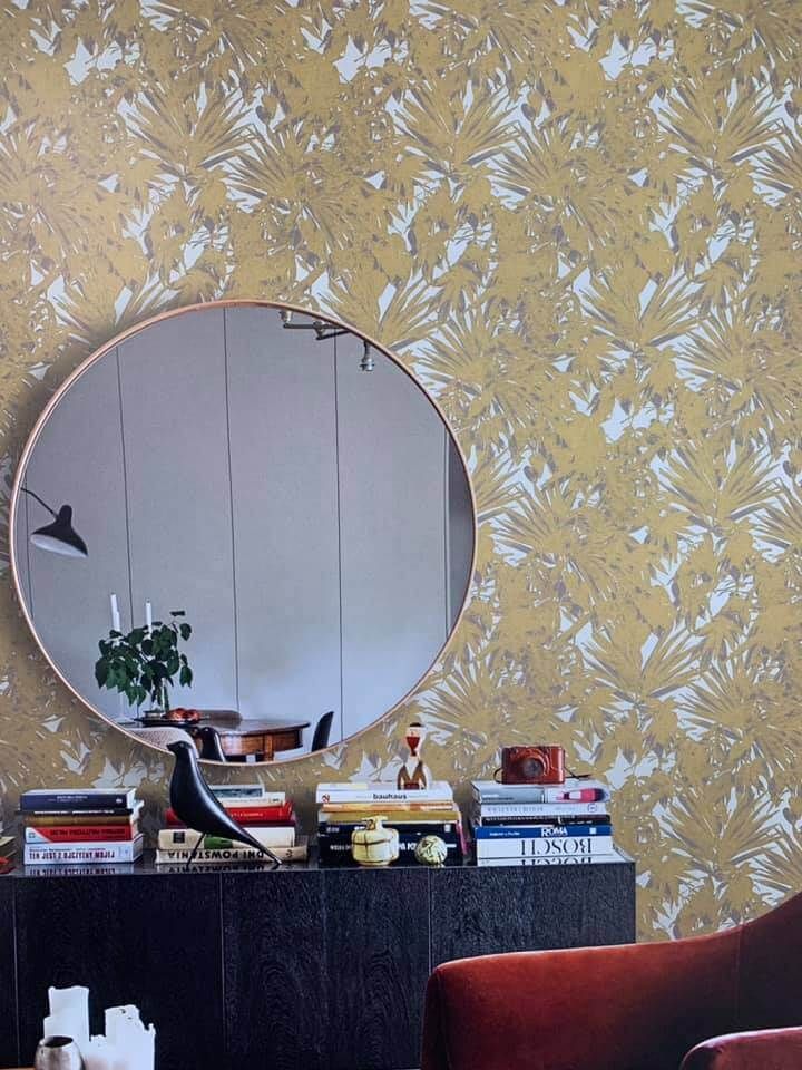 Un soggiorno con uno specchio rotondo sul muro
