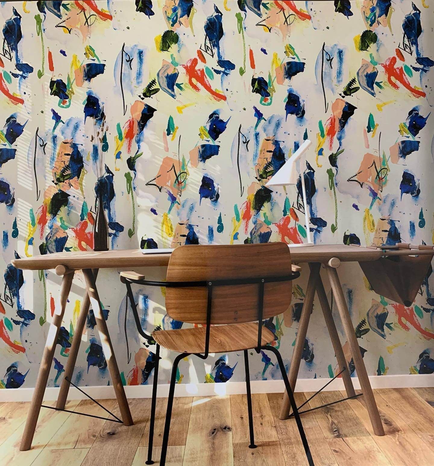 Una scrivania e una sedia davanti a un muro colorato