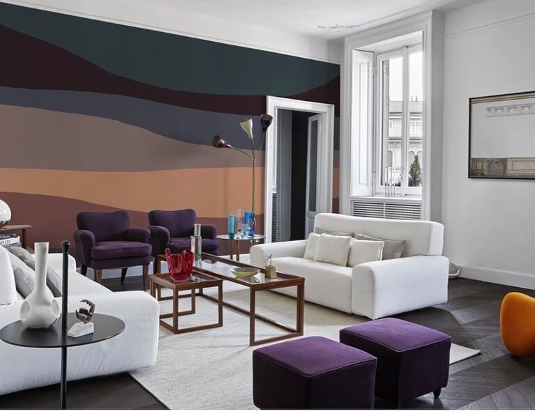 Un soggiorno con un divano bianco e pouf viola