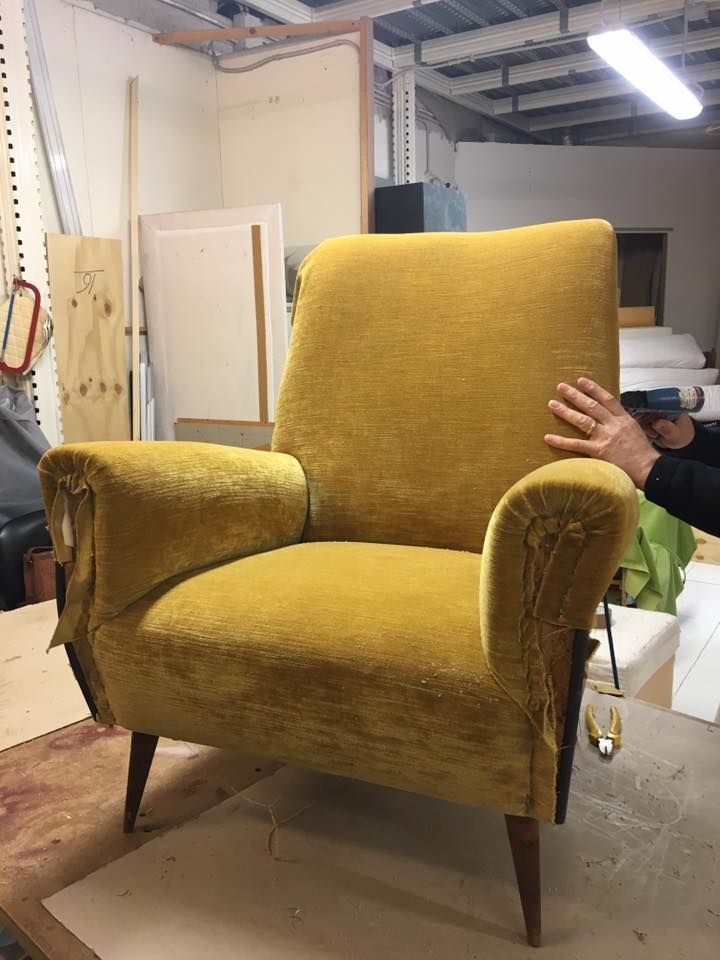 Una sedia gialla è appoggiata su un tavolo di legno in una stanza.