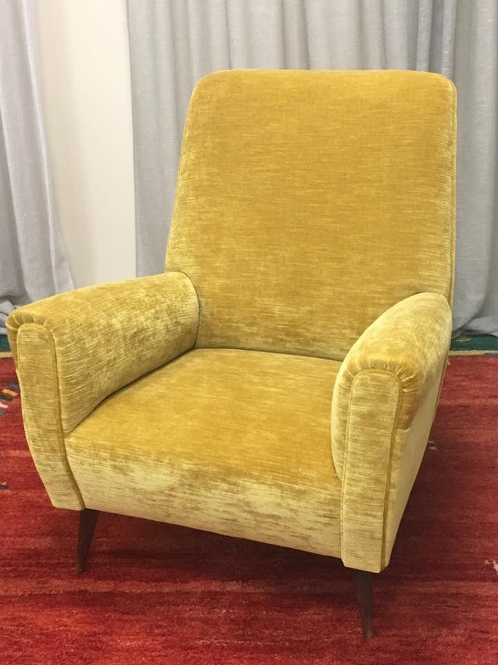 Una sedia gialla è appoggiata su un tappeto rosso in una stanza.