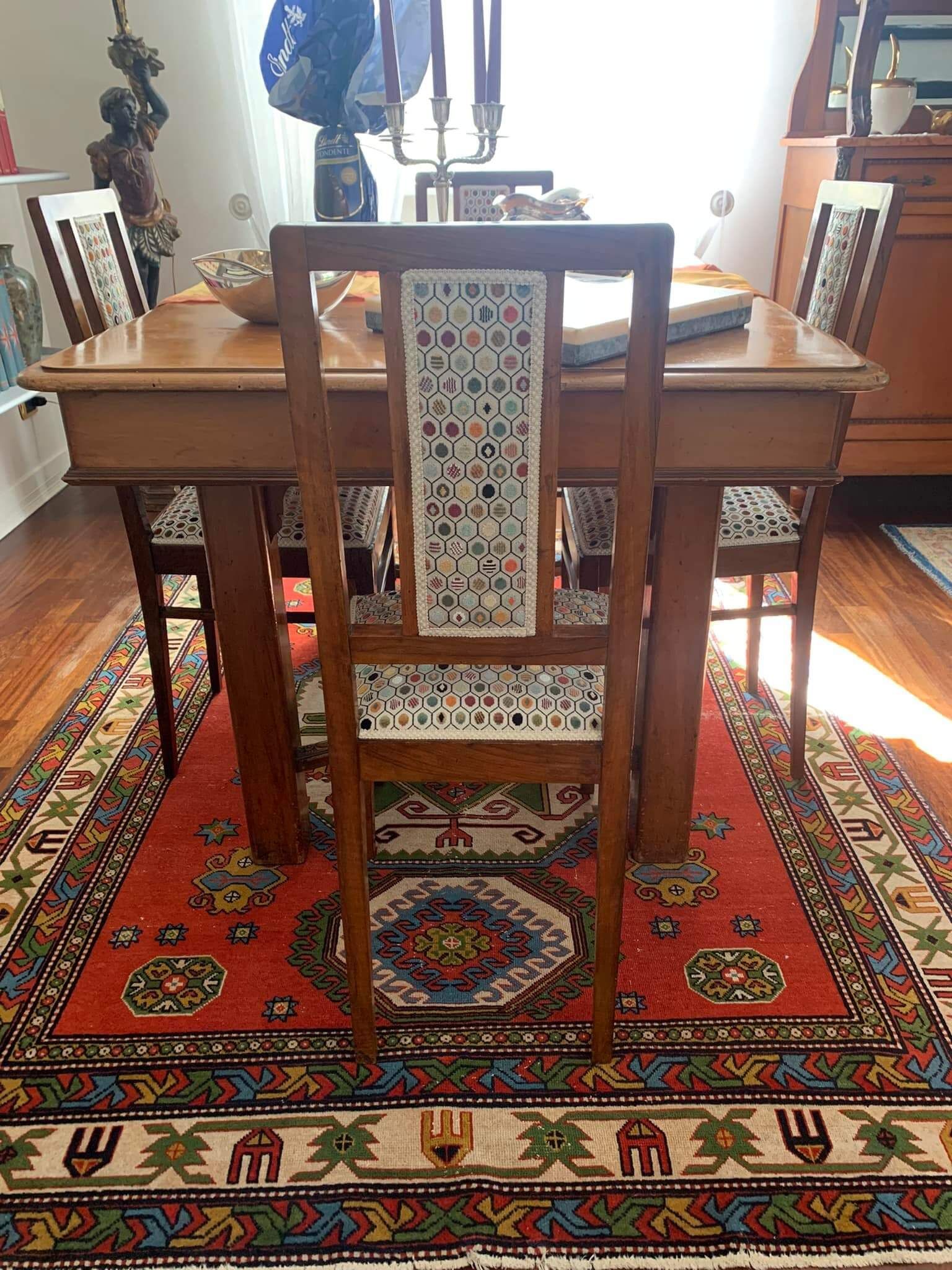 Un tavolo da pranzo con sedie e un tappeto sul pavimento.