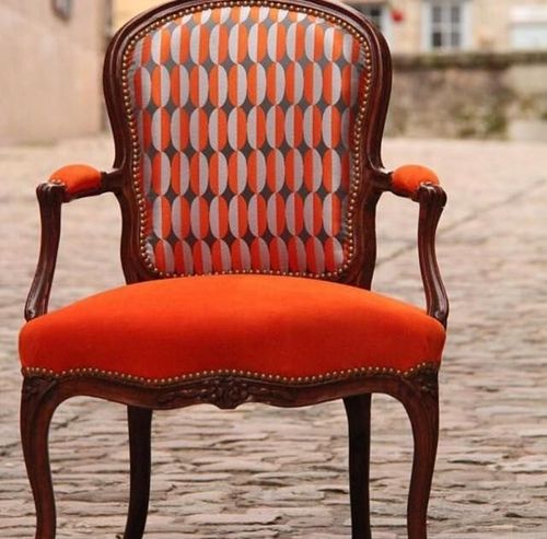 Una sedia arancione con un motivo geometrico sullo schienale