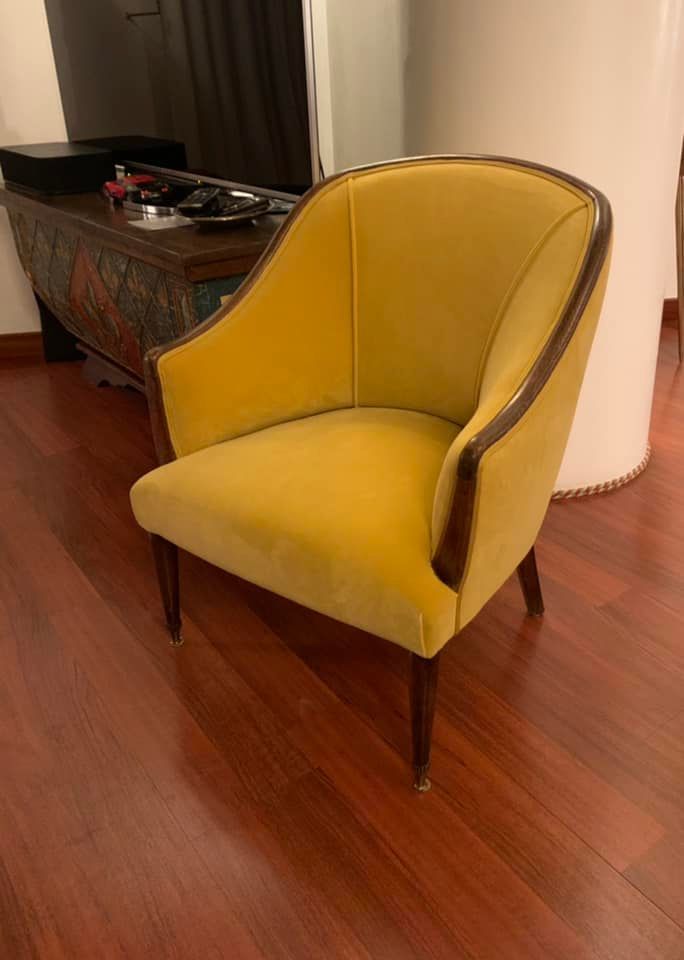 Una sedia gialla è appoggiata sul pavimento di legno in una stanza.