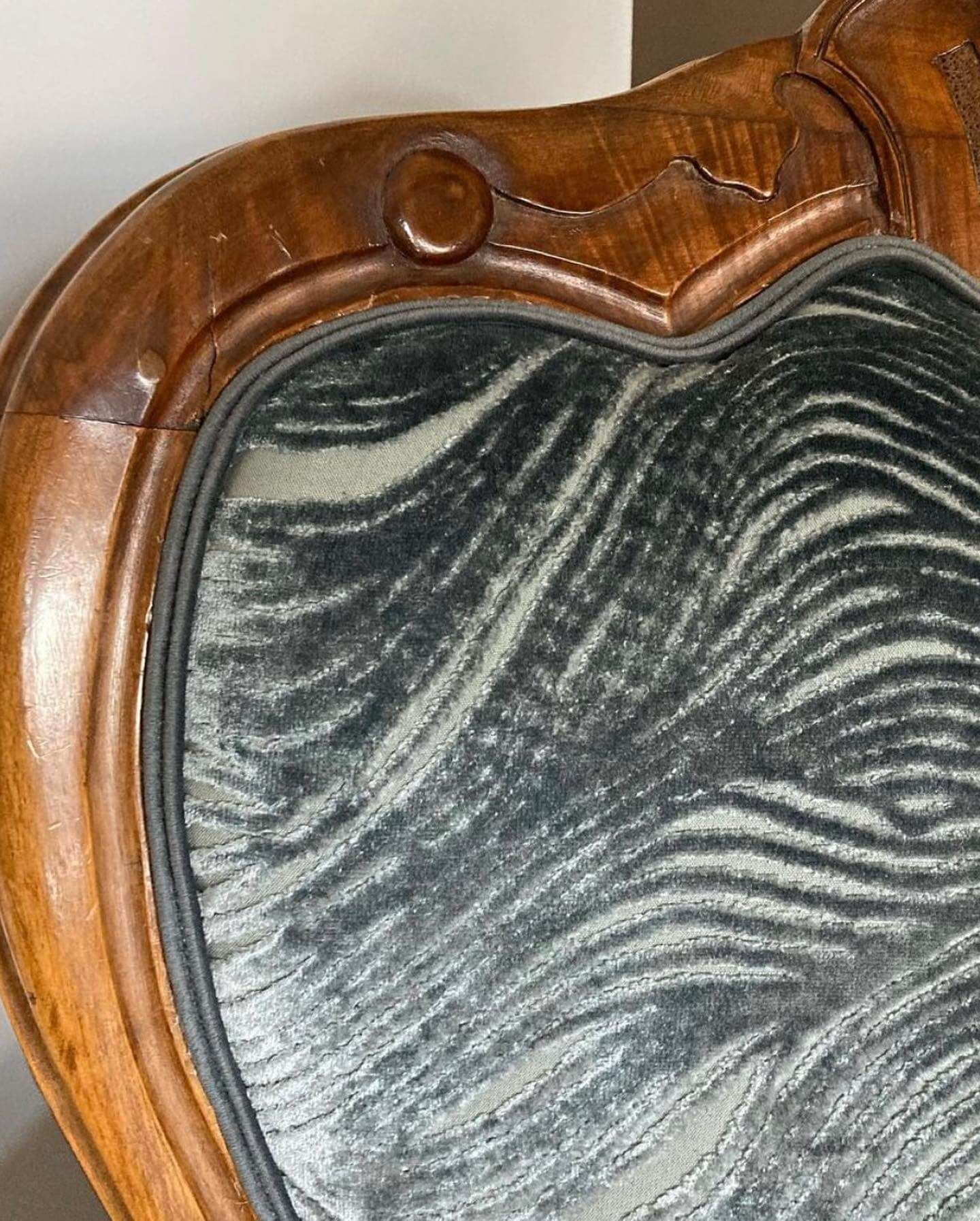 Primo piano di una sedia in legno con cuscino a stampa zebrata.