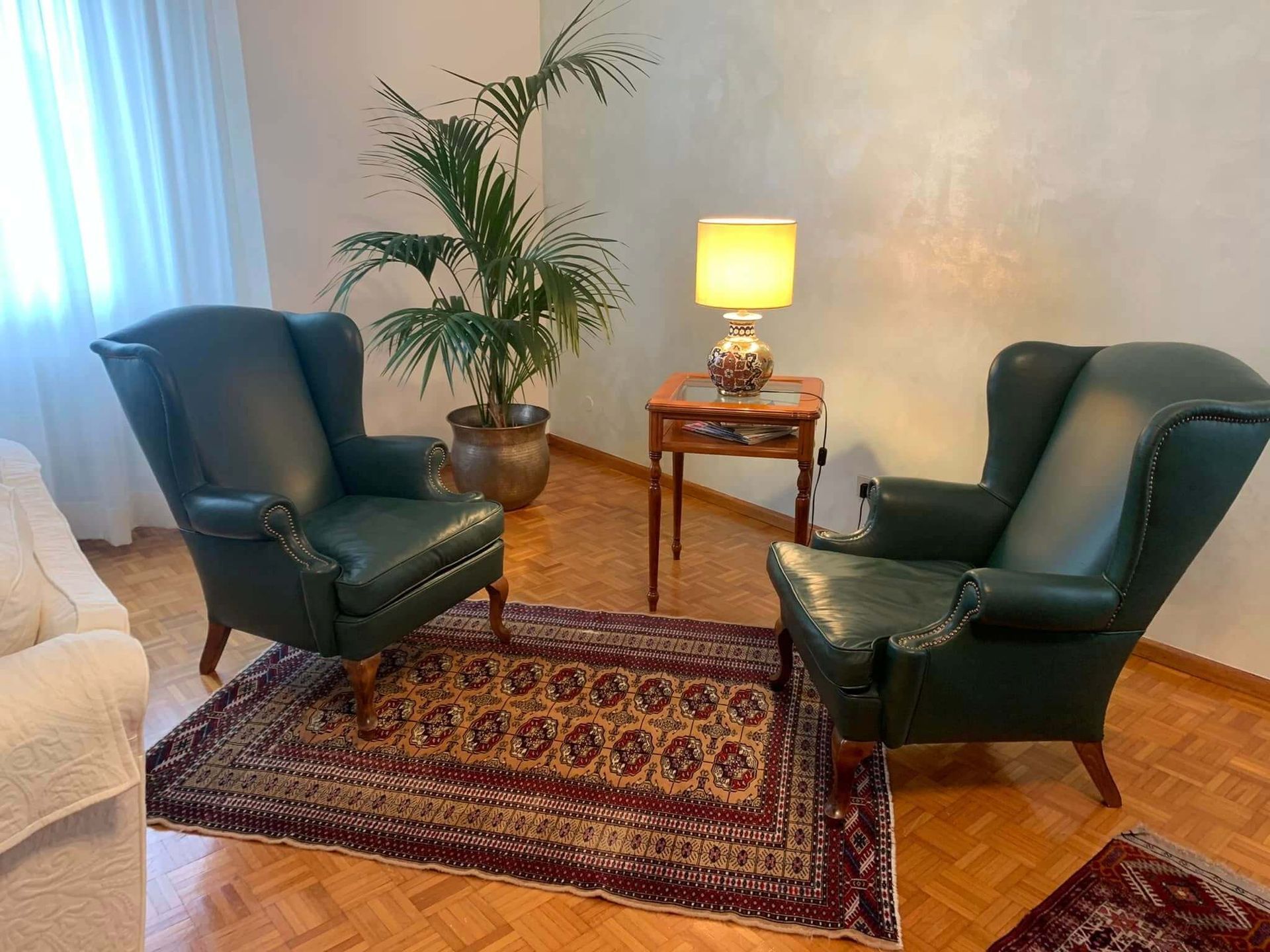 Due sedie verdi sono posizionate una accanto all'altra in un soggiorno.