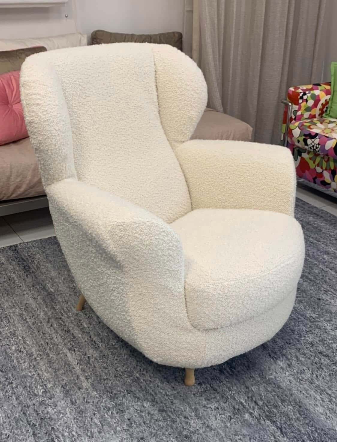 Una sedia bianca è appoggiata su un tappeto in un soggiorno.