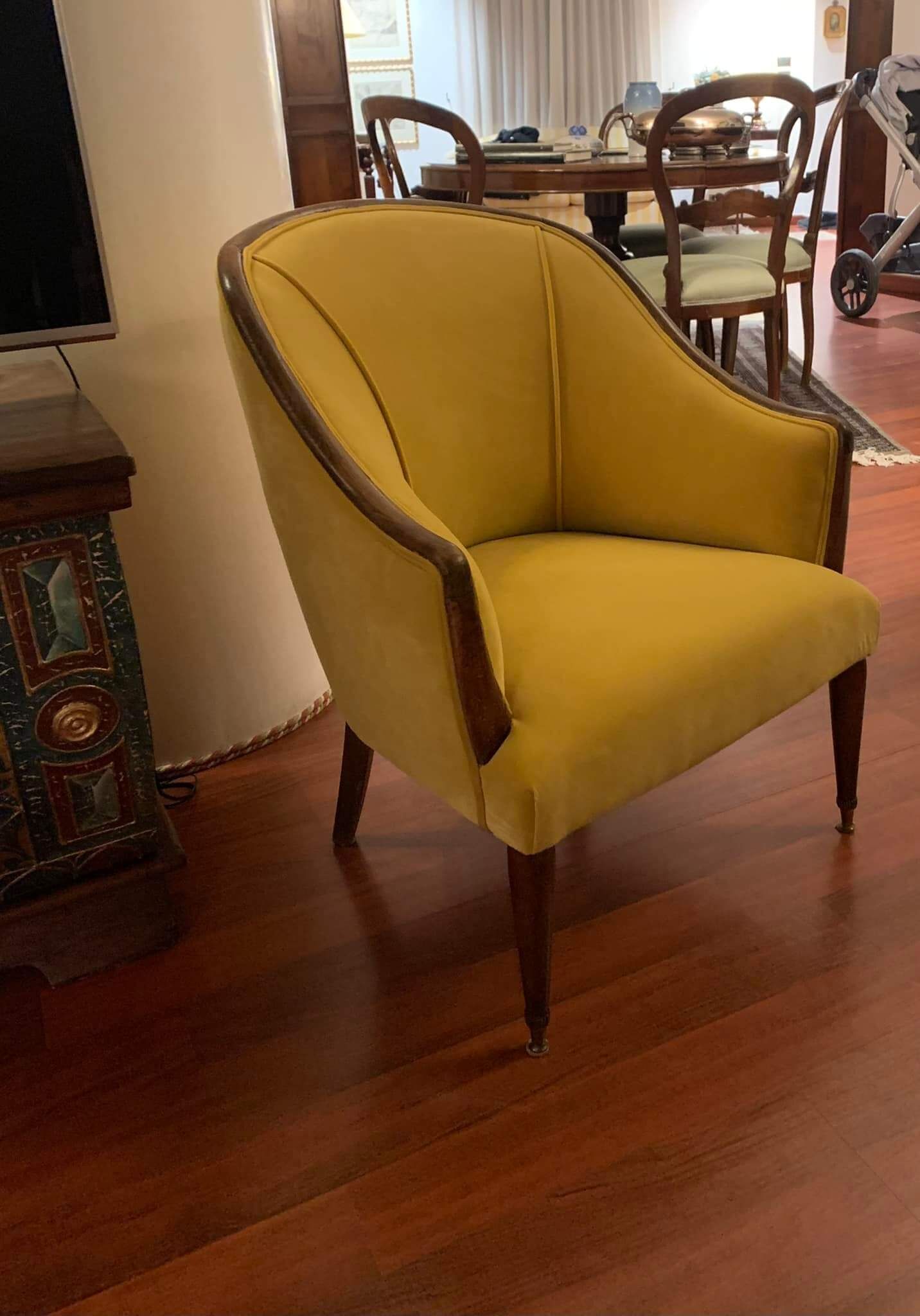 Una sedia gialla è appoggiata sul pavimento di legno in un soggiorno.