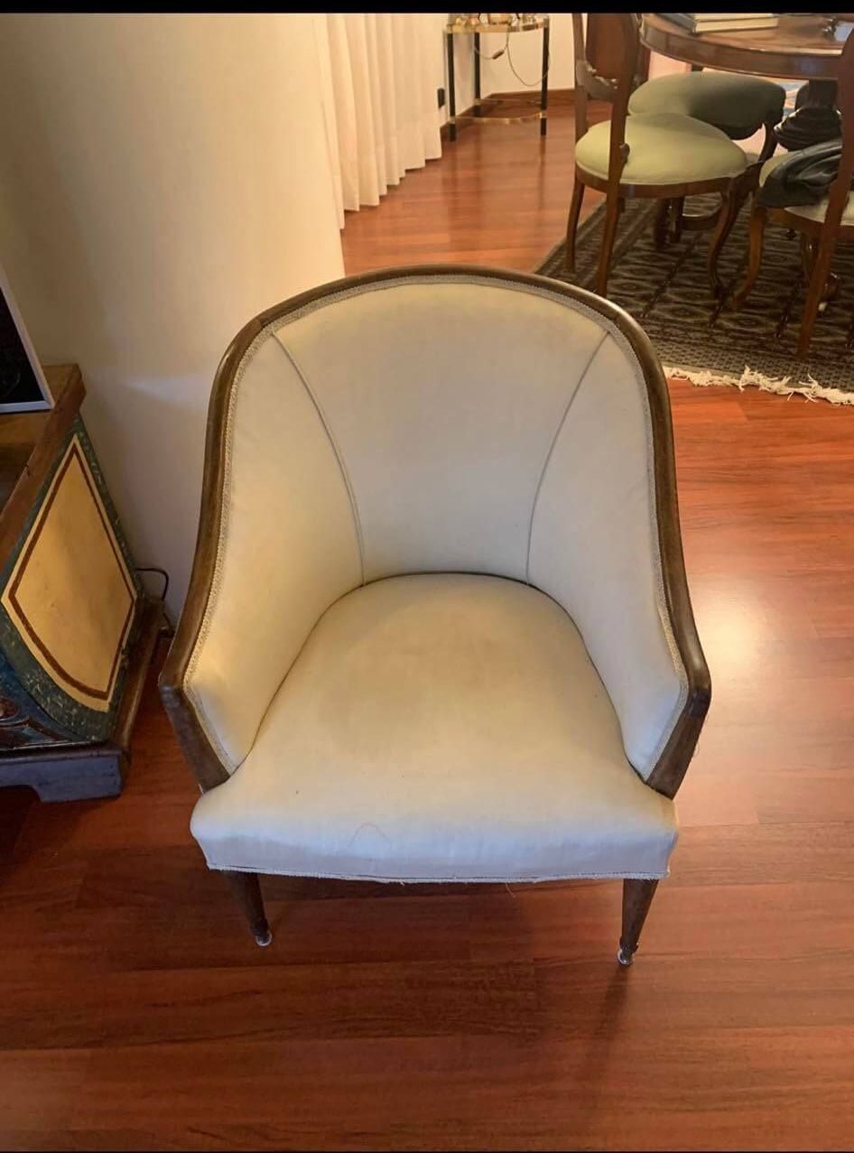 Una sedia bianca è appoggiata sul pavimento di legno in un soggiorno.