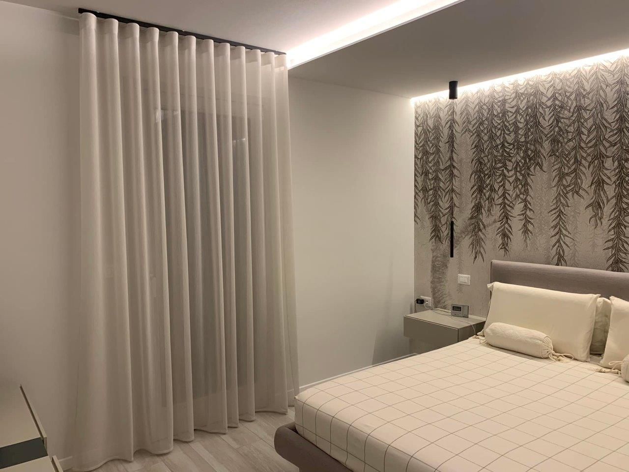 Una camera da letto con un letto e tende alla finestra.