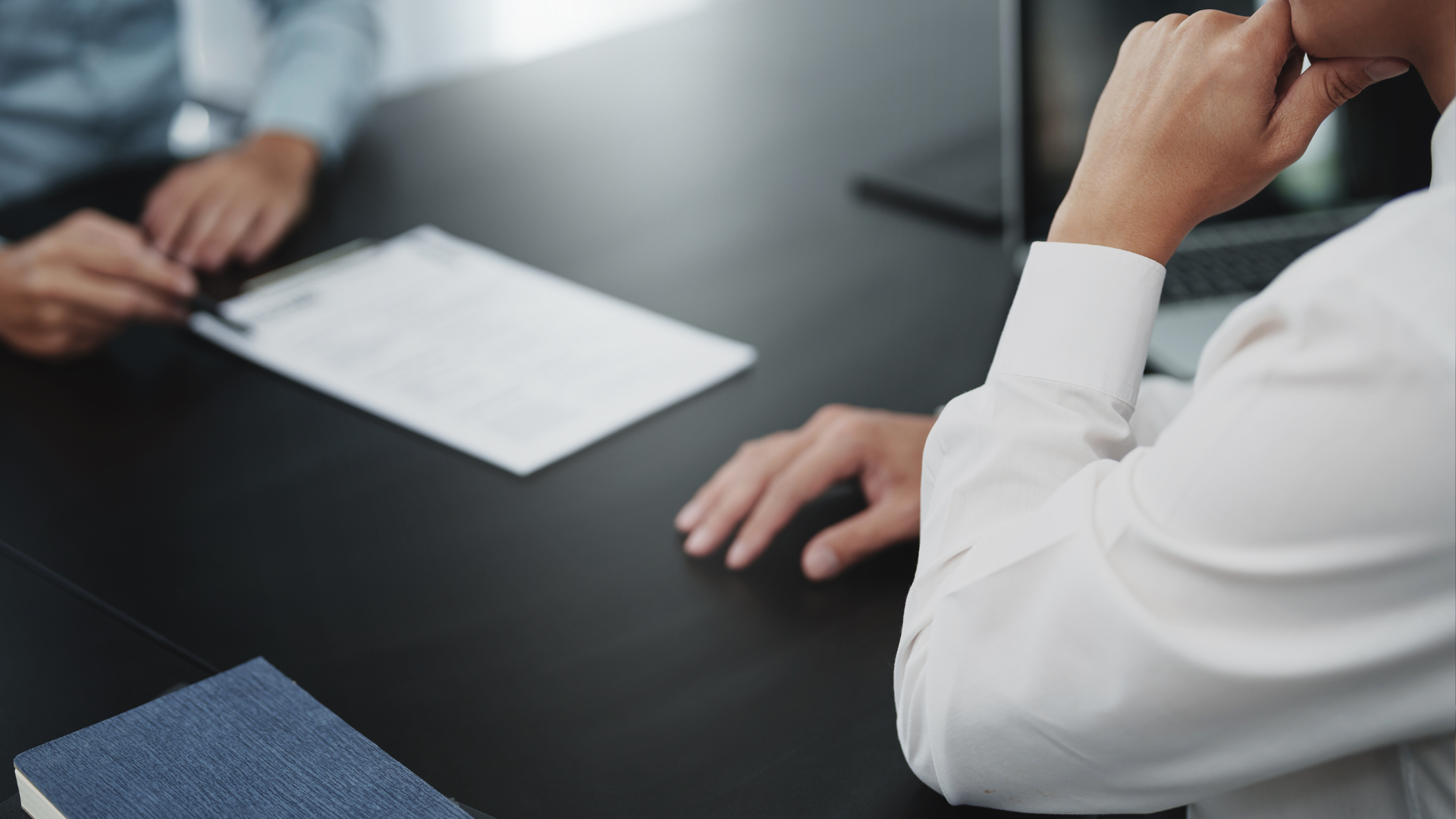 A man and a woman are sitting at a table talking to each other.