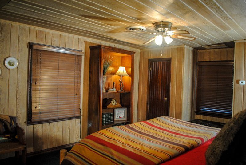 A bedroom with a bed and a ceiling fan