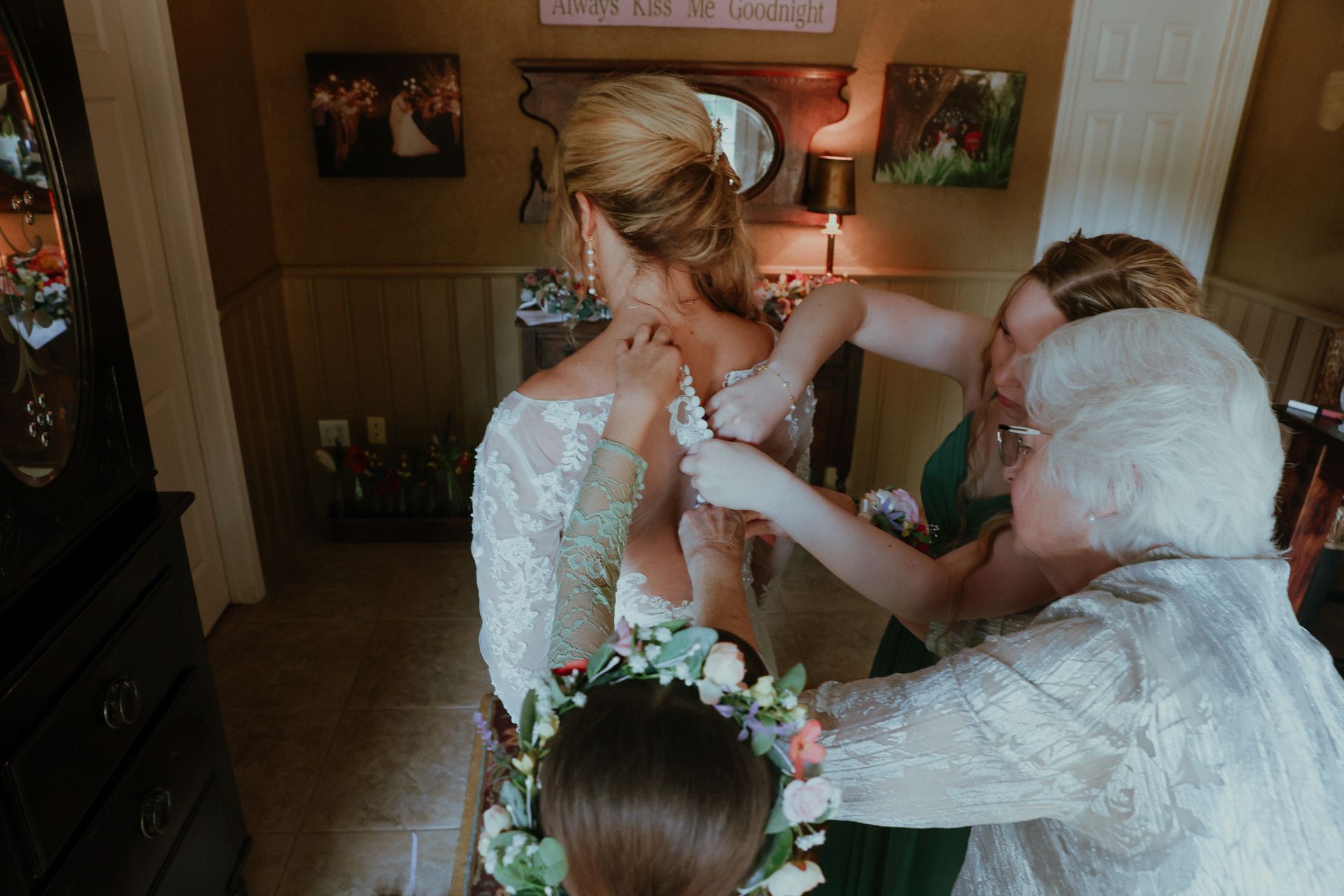 A bride and groom are kissing in front of a building with a veil blowing in the wind.