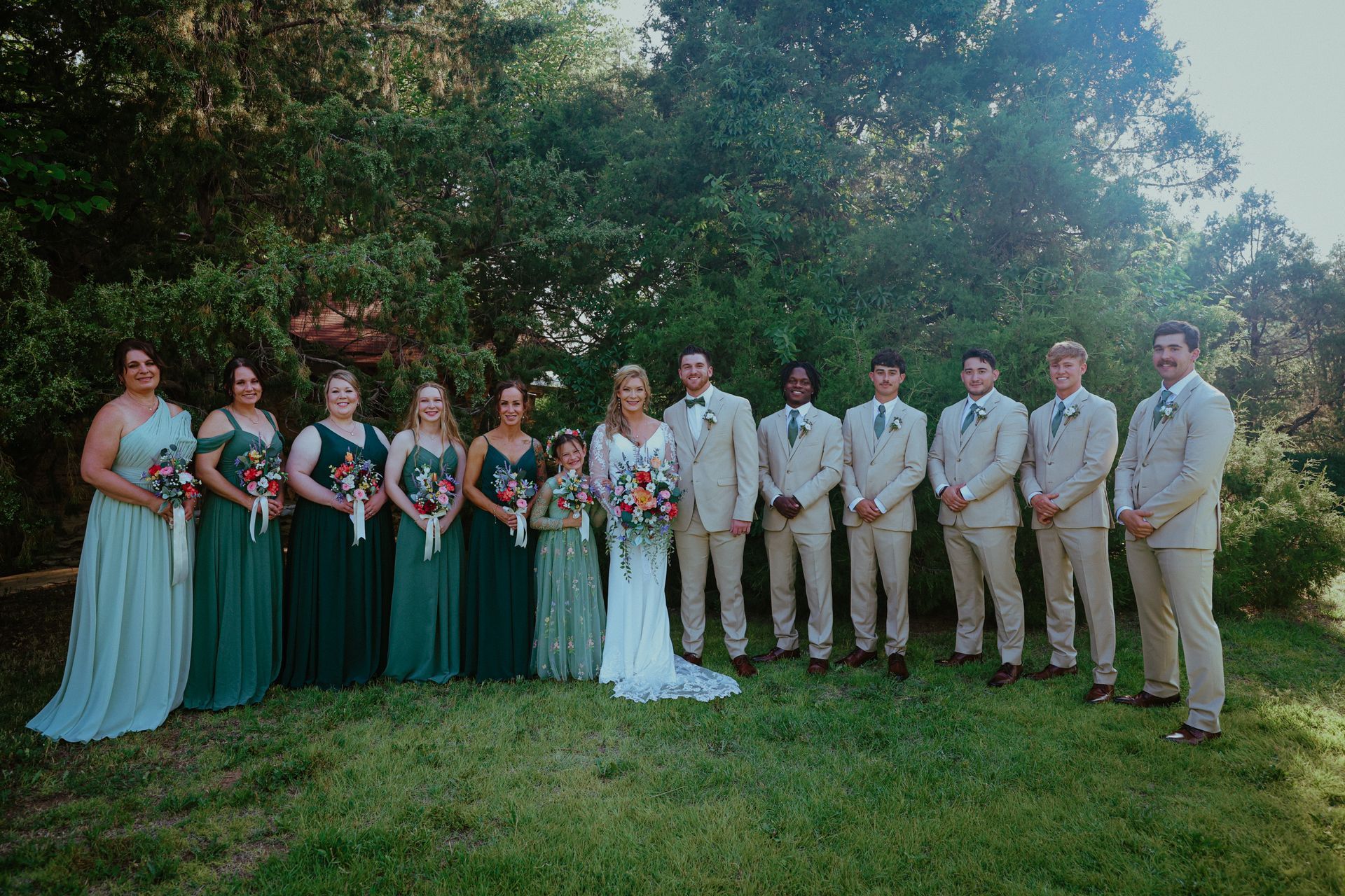The bride and groom are posing for a picture with their wedding party.