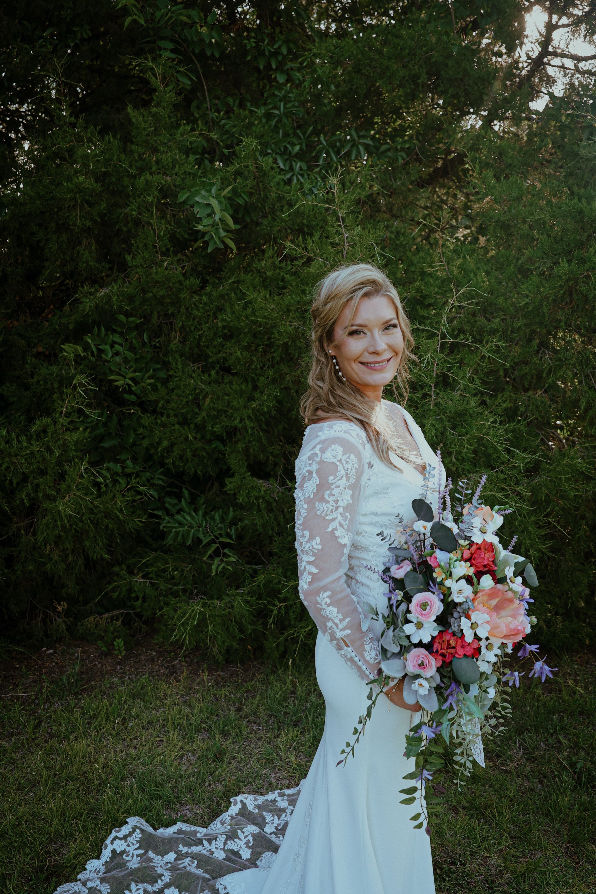 A bride in a wedding dress is holding a bouquet of flowers.