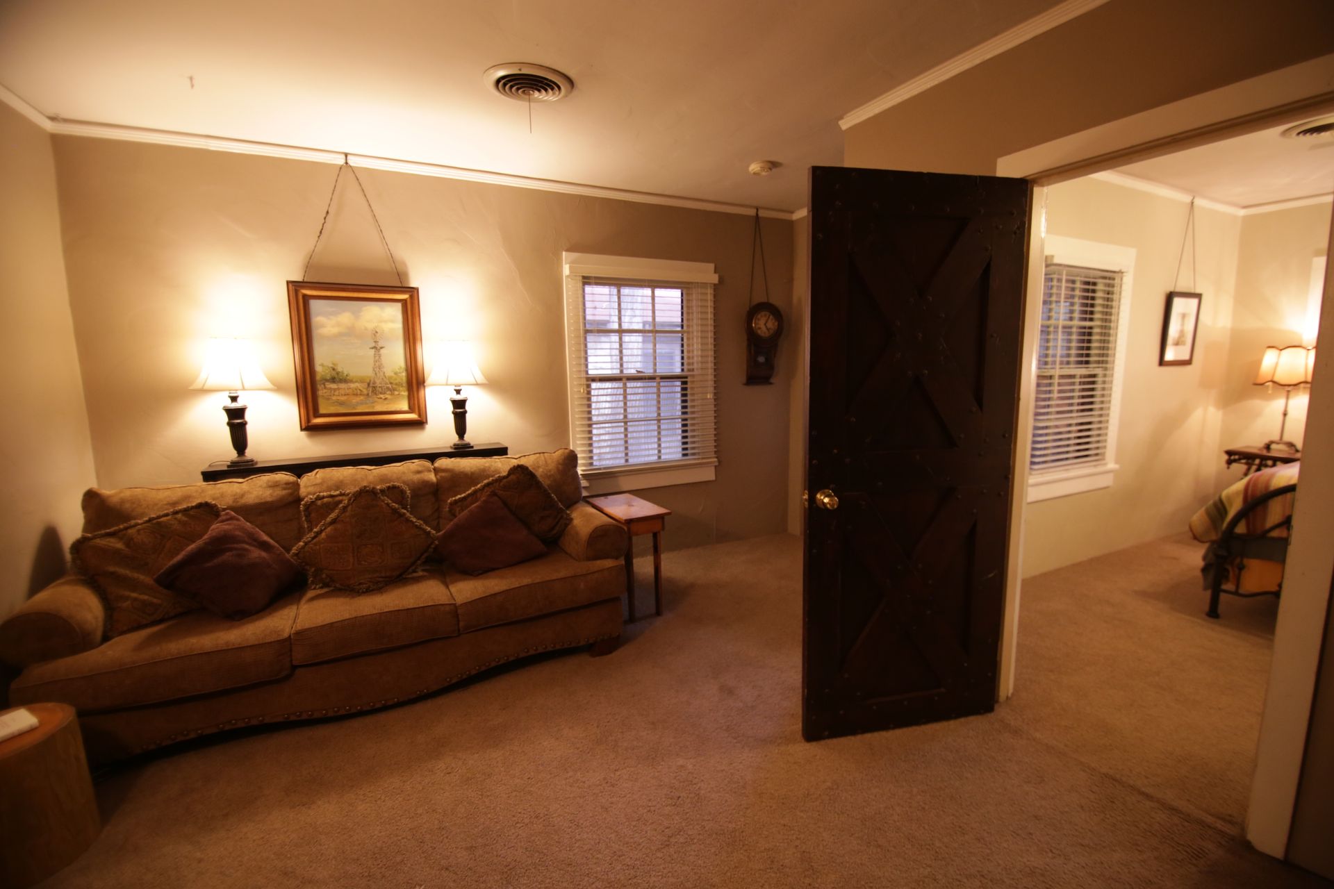 A living room with a couch and two windows
