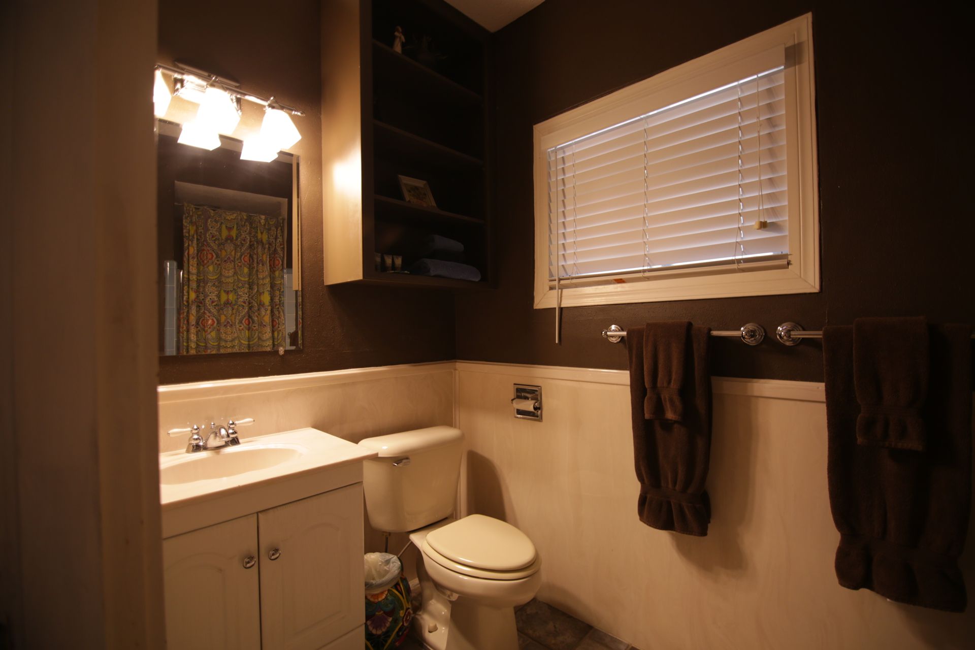 A bathroom with a toilet a sink and a window