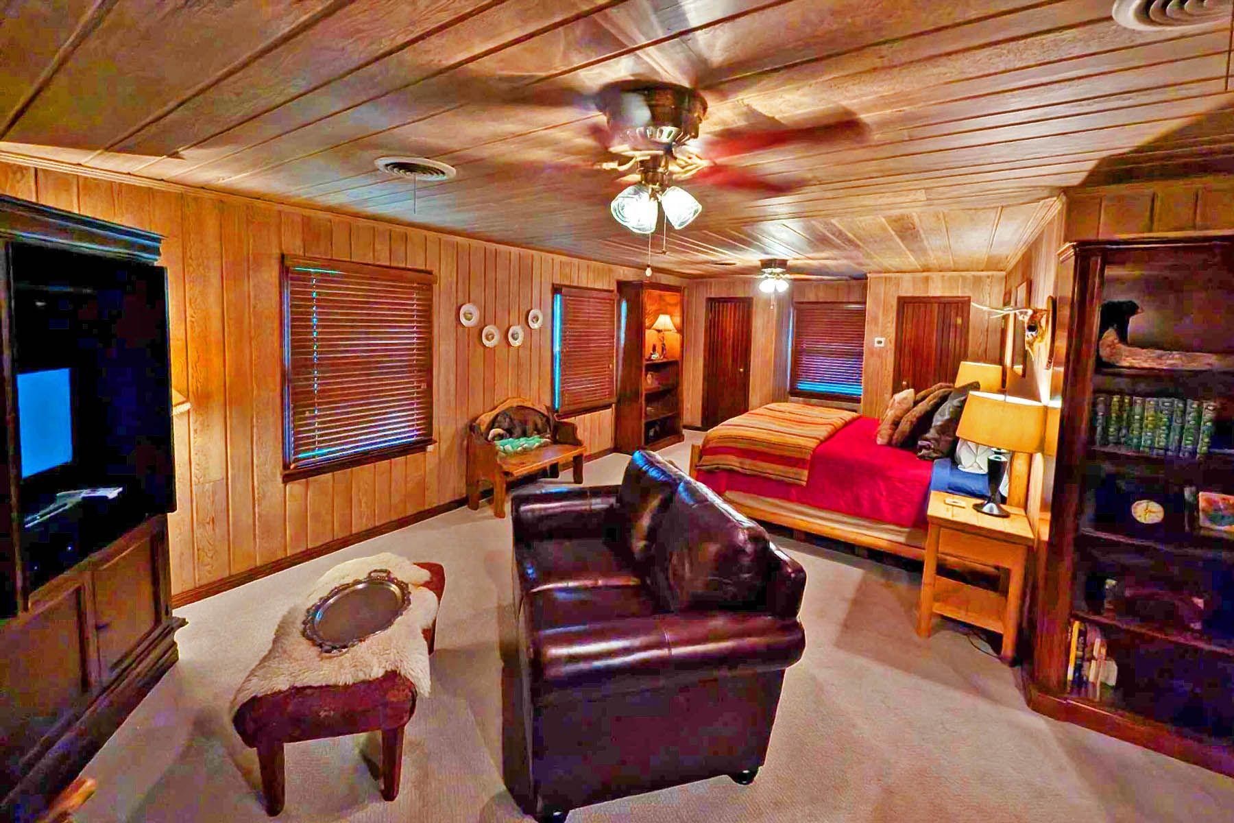 A living room with a couch , chair , table and television.