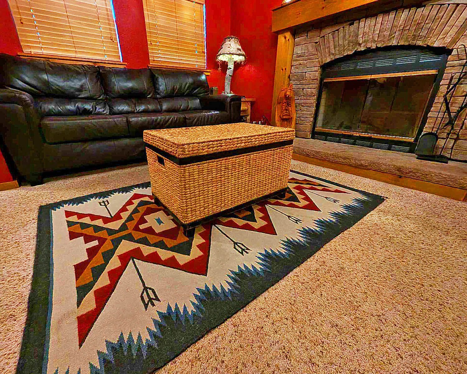 A living room with a couch , fireplace and rug