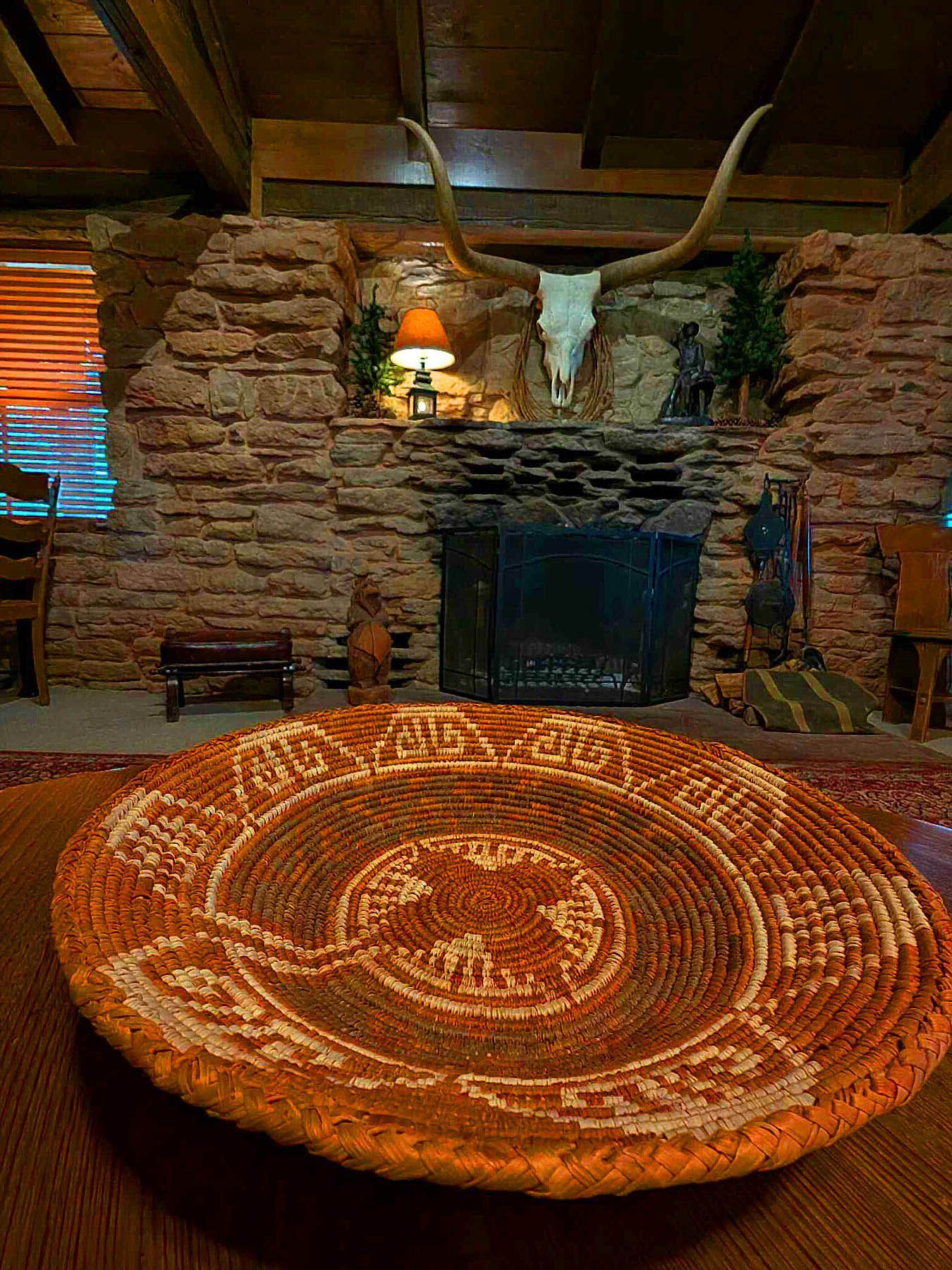A basket is sitting on a table in front of a fireplace in a living room.