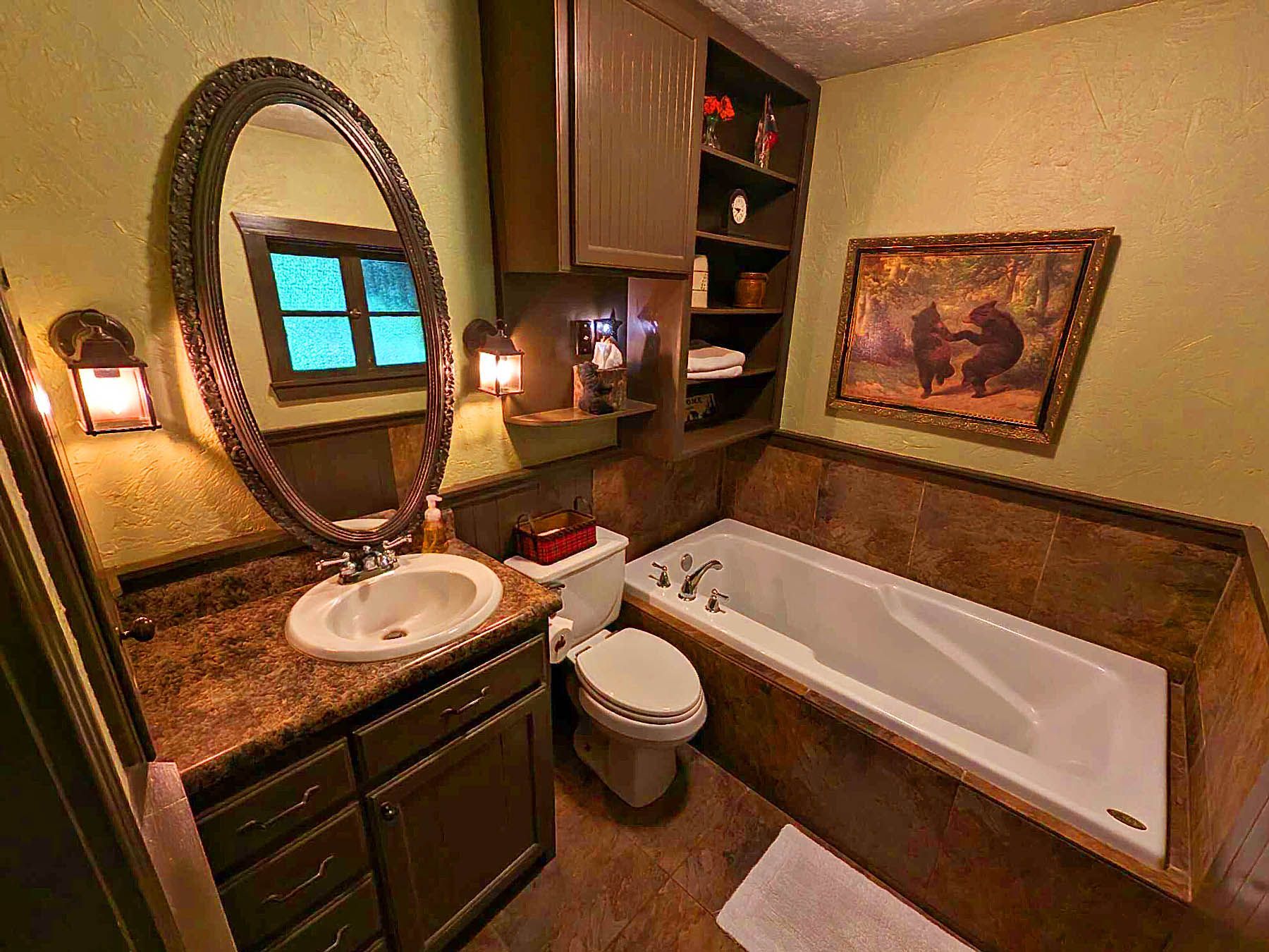 A bathroom with a tub , toilet , sink and mirror.