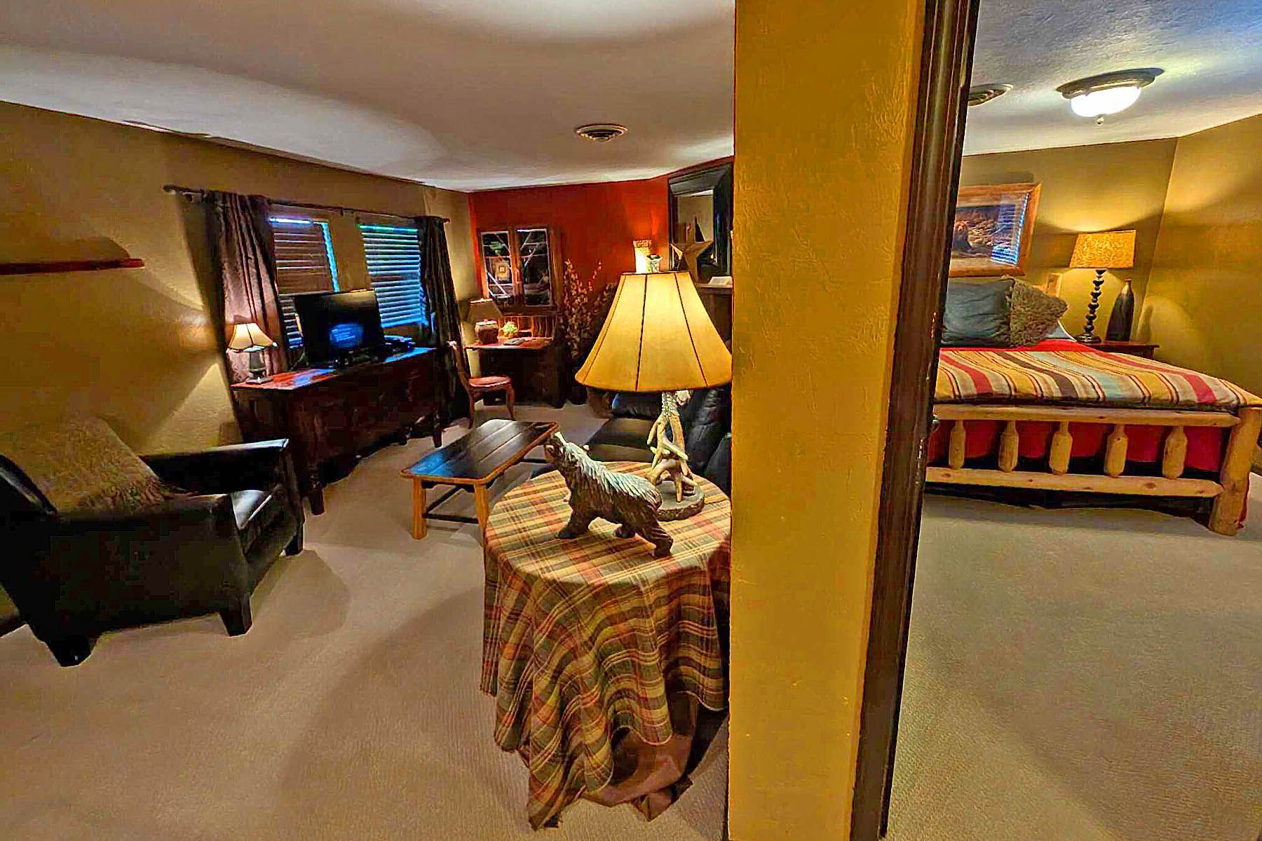 A bedroom with a bed , lamps , pillows and a picture on the wall.