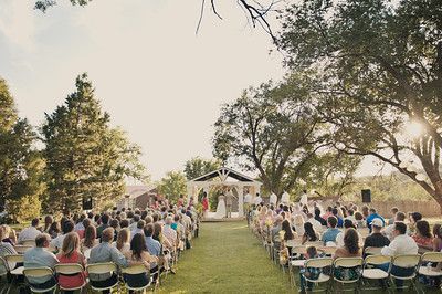 A large group of people are sitting in chairs at a wedding ceremony.