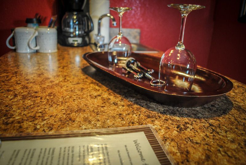 Two wine glasses are on a tray on a counter next to a menu.