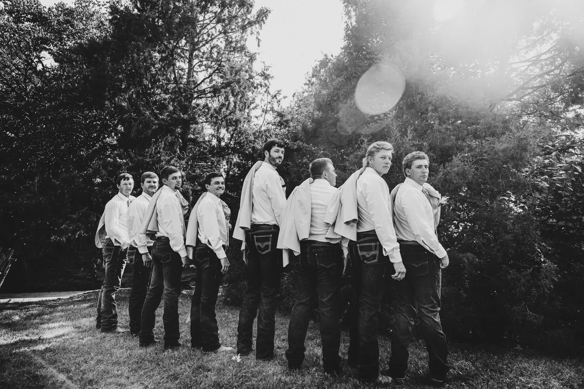 A black and white photo of a group of men standing in a circle.