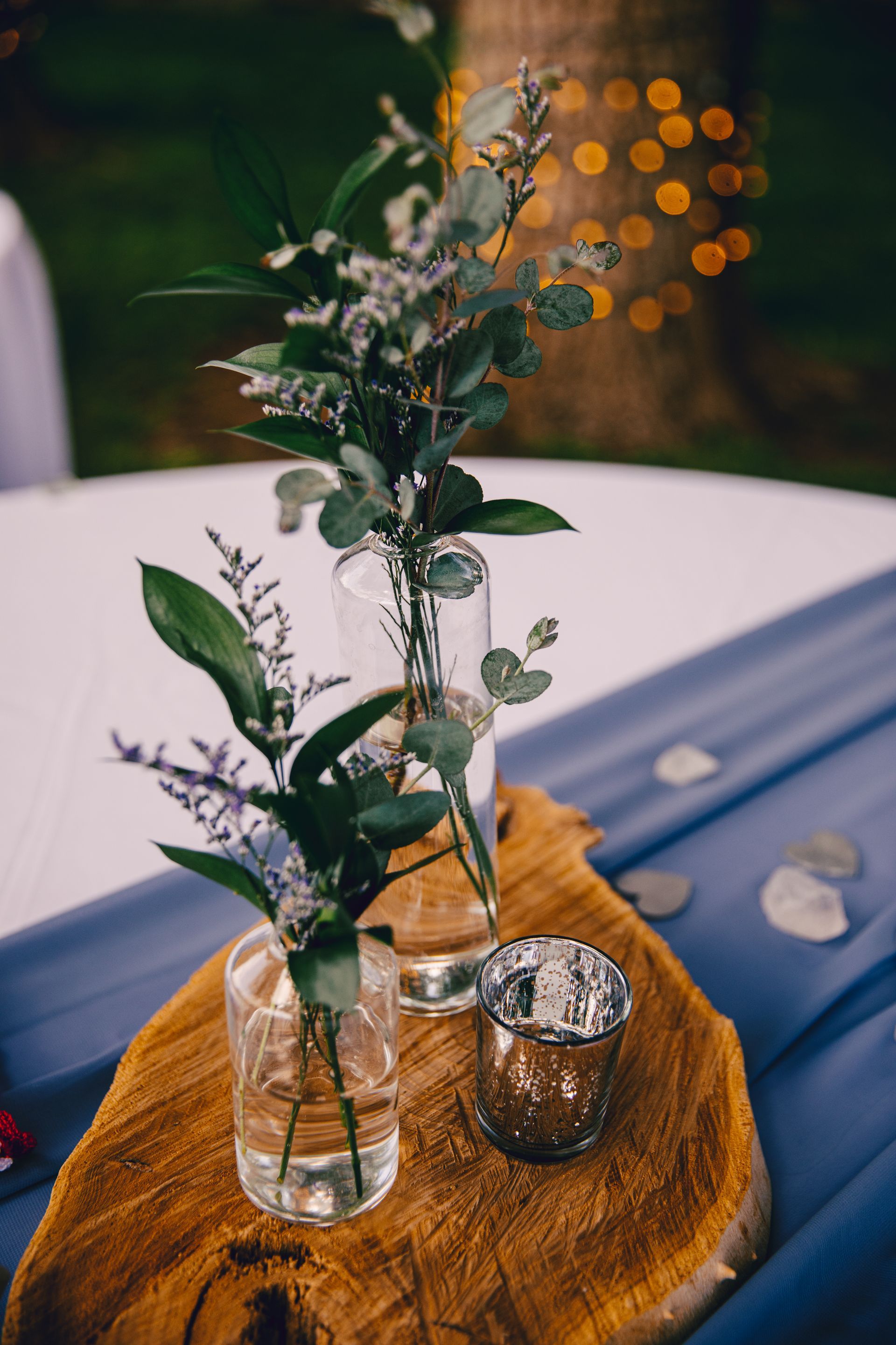Two vases filled with flowers are sitting on a wooden table.
