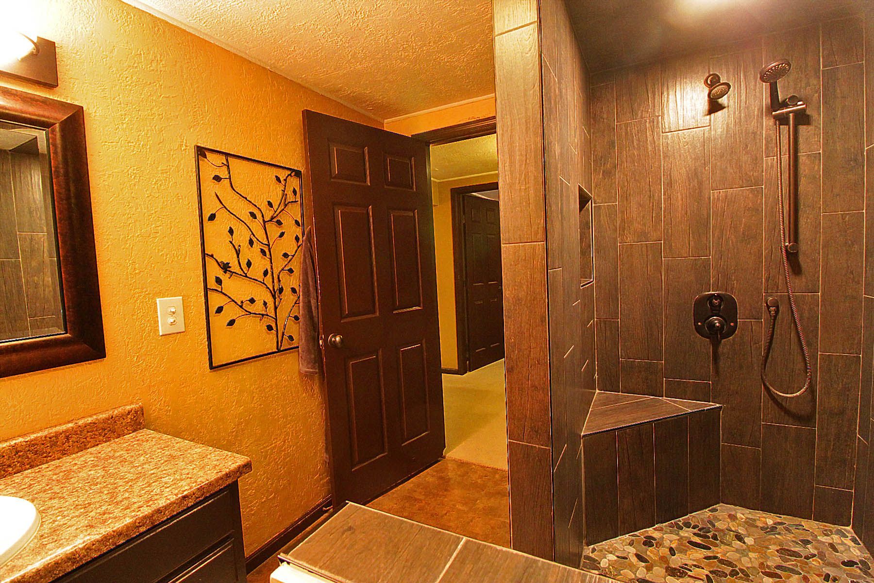 A bathroom with a walk in shower and a sink