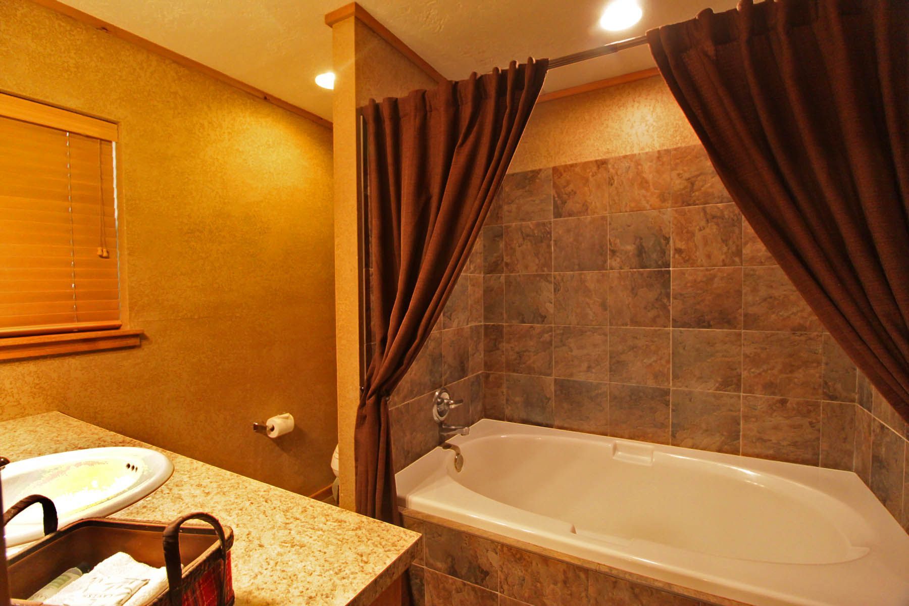 A bathroom with a tub , sink , and shower.