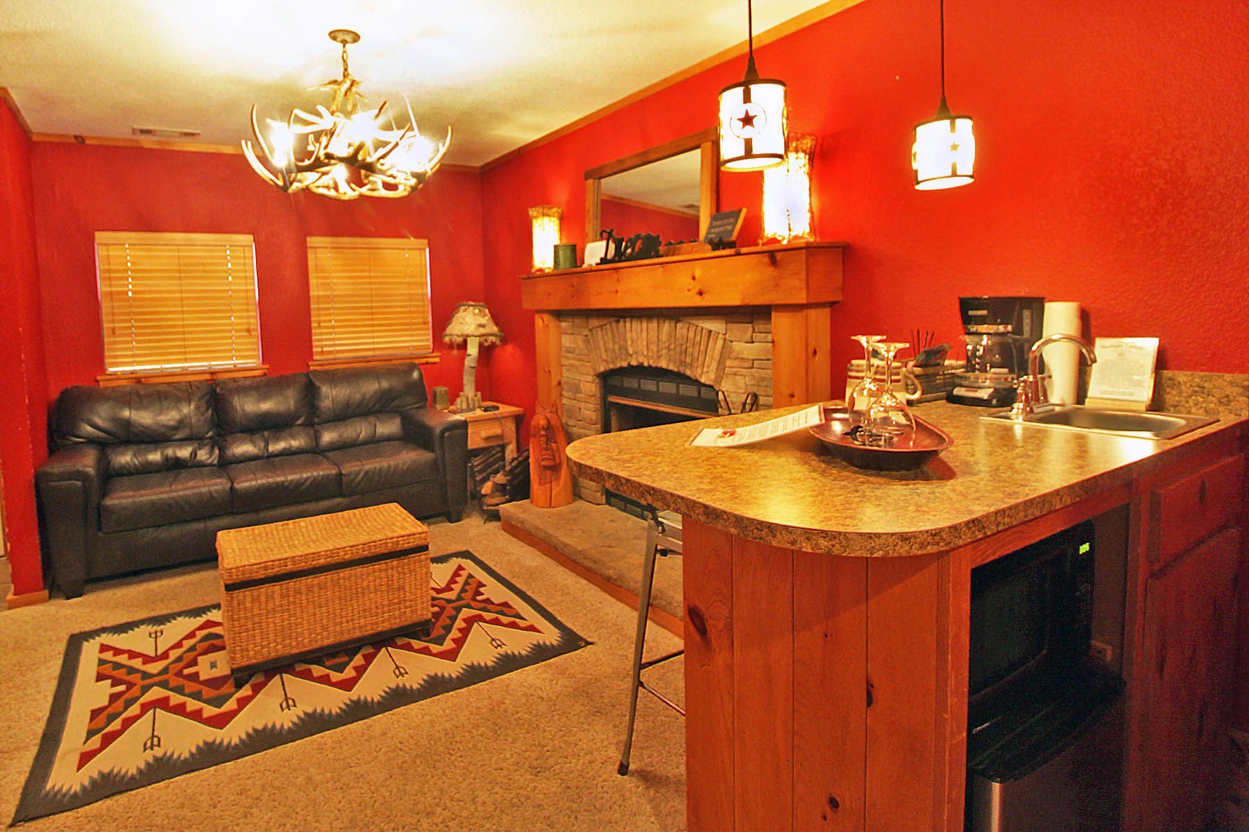 A living room with a black couch and a fireplace