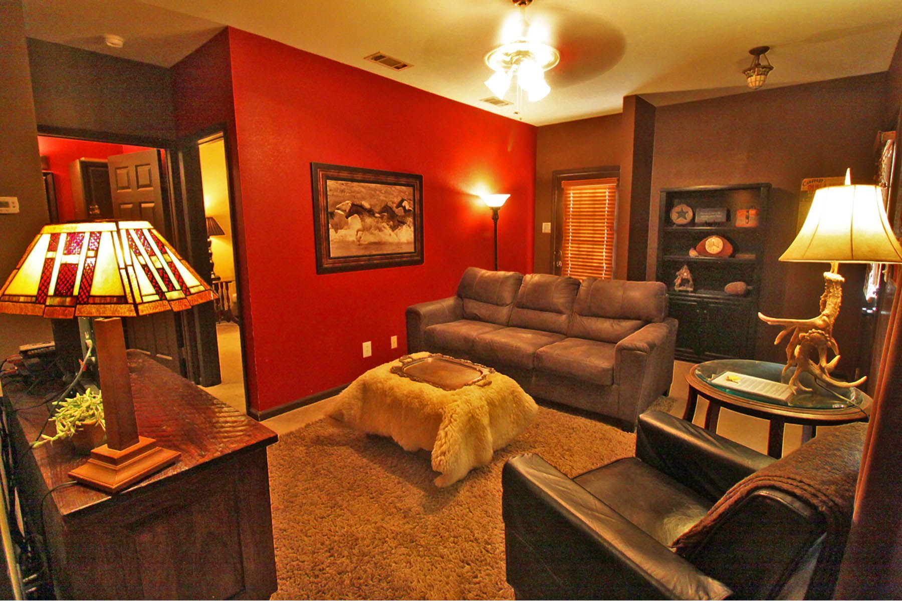 A living room with a couch a chair and a lamp