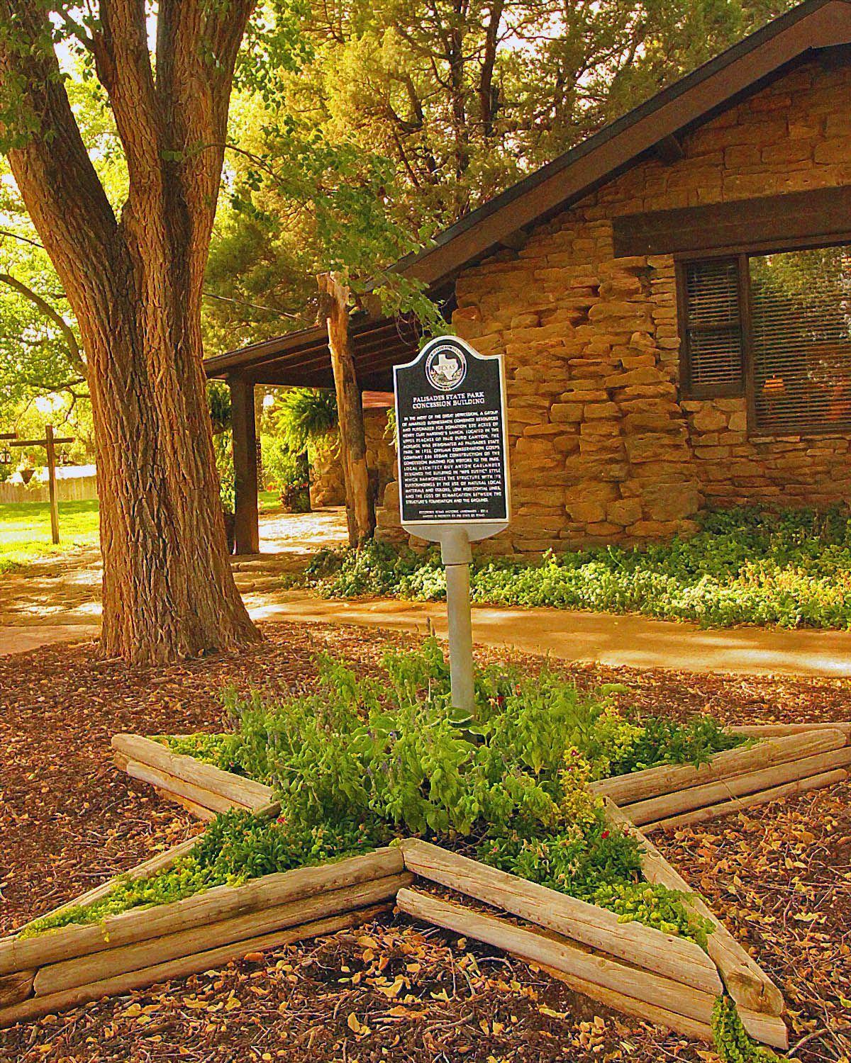 A historical marker in front of a stone building