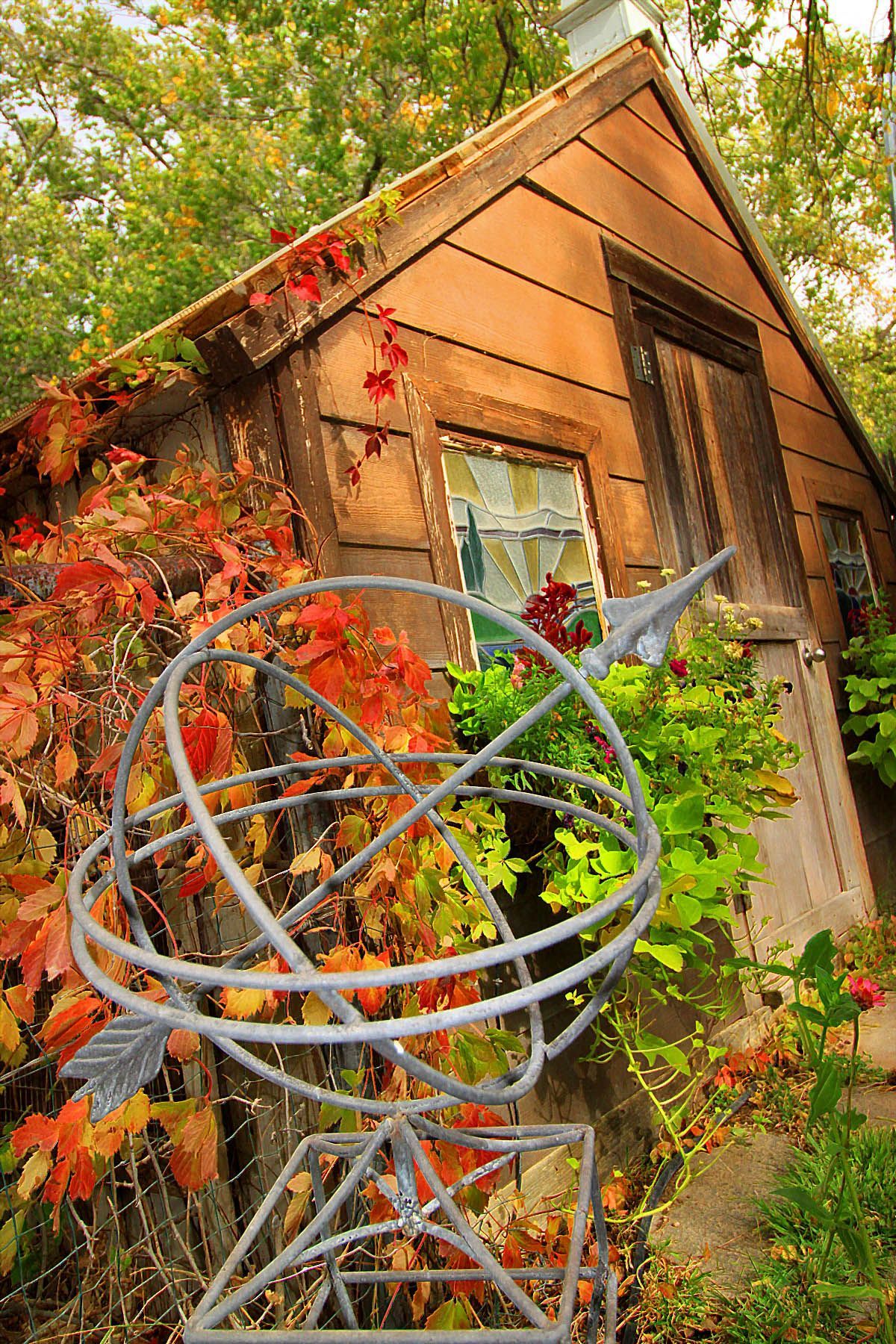 A shed with a bird statue in front of it