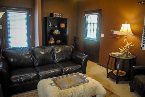 A living room with a couch , chair , table and lamp.