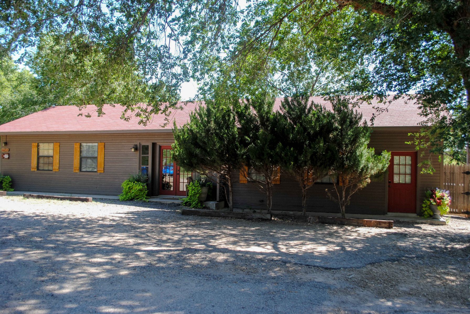 A house with a red roof and trees in front of it