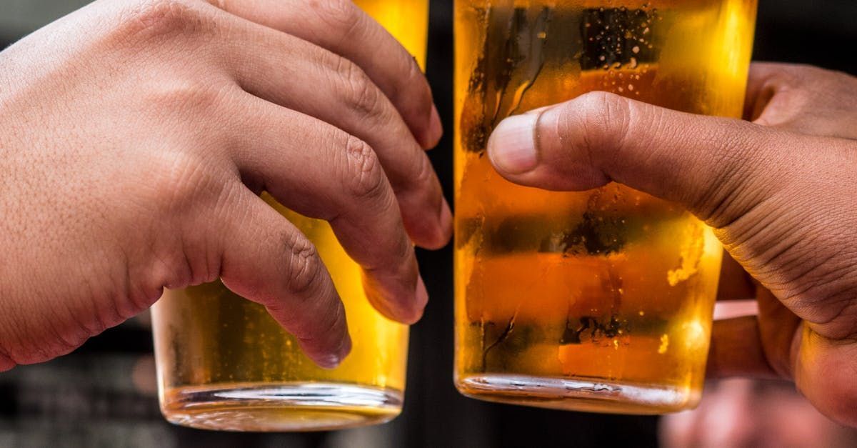 Two people are toasting with two glasses of beer.