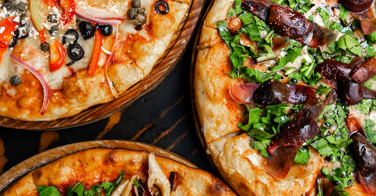 Three different types of pizzas are sitting on a wooden table.