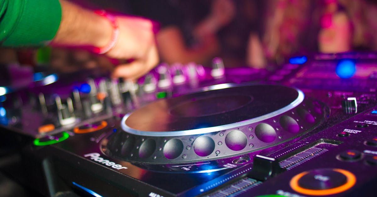 A dj is playing music at a party in front of a crowd.