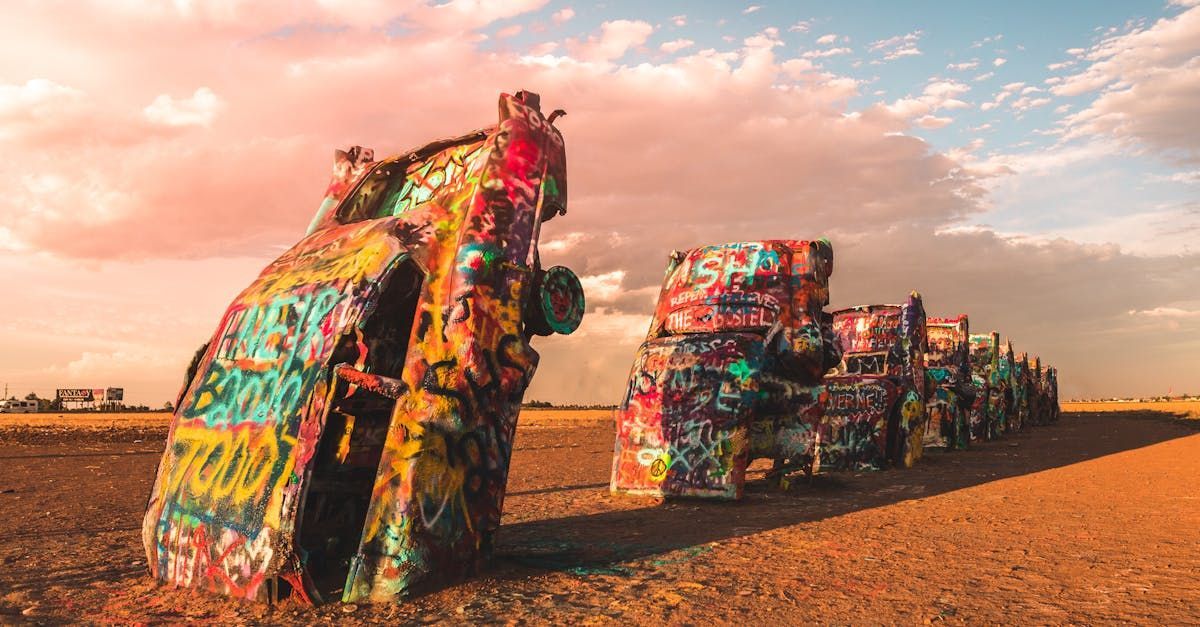 A bunch of colorful cars are sitting on top of each other in a field.